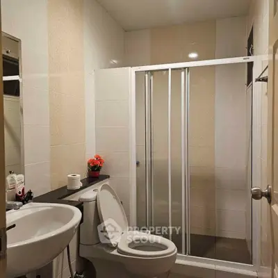 Modern bathroom with shower enclosure and sleek fixtures in a contemporary home.