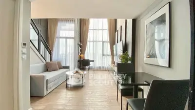 Modern living room with high ceilings and large windows, featuring stylish furniture and decor.