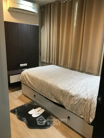 Cozy bedroom with modern decor and air conditioning, featuring a comfortable bed and stylish curtains.