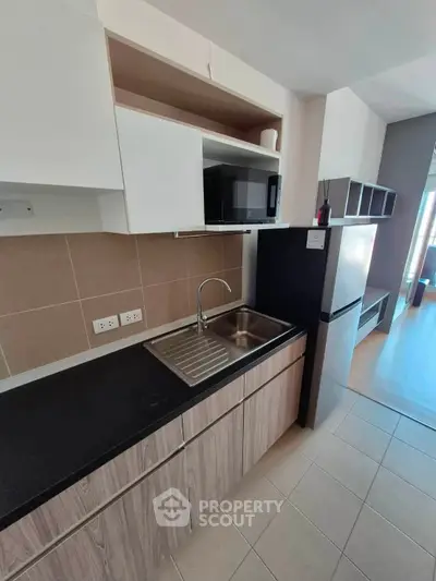 Modern kitchen with sleek cabinetry and stainless steel appliances in a contemporary apartment.