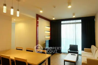Spacious modern living room with elegant dining area and large window view.