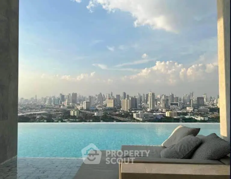 Luxurious rooftop infinity pool with stunning city skyline view, perfect for relaxation and urban living.