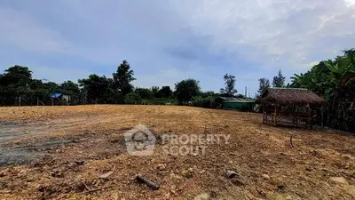 Expansive land plot with rustic gazebo, ideal for development or agriculture.