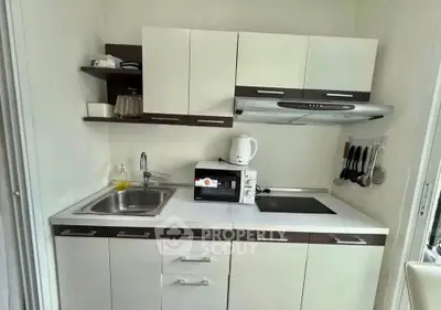 Compact modern kitchen with sleek cabinets and built-in appliances, perfect for urban living.