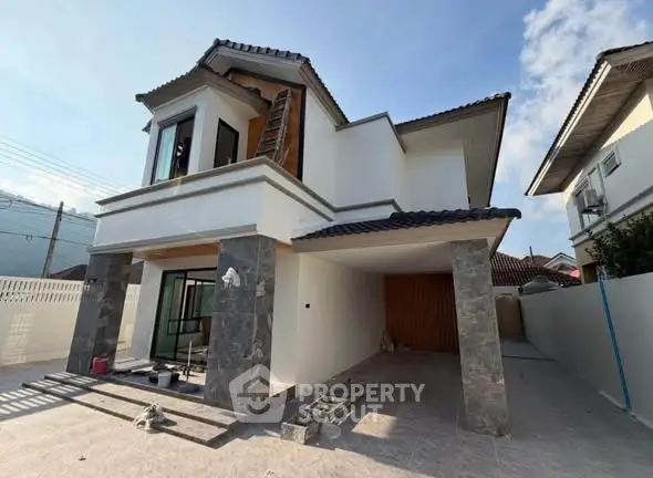 Modern two-story house with stone accents and spacious driveway in a suburban neighborhood.