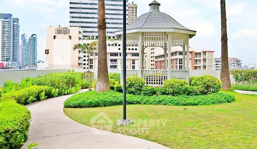 Charming garden gazebo with lush greenery and city skyline views, perfect for relaxation and outdoor gatherings.