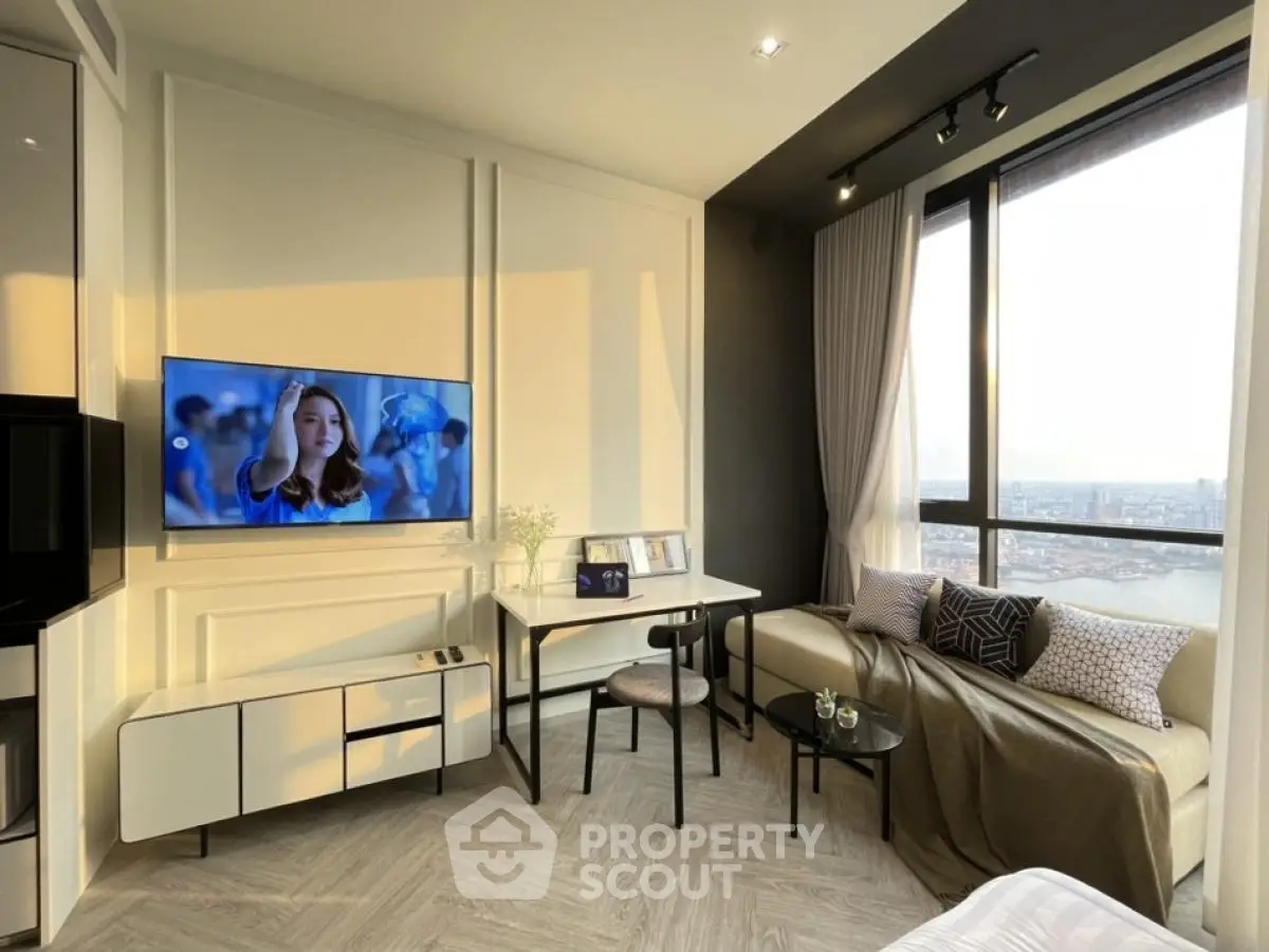 Modern living room with large window and stylish decor, featuring a cozy seating area and wall-mounted TV.