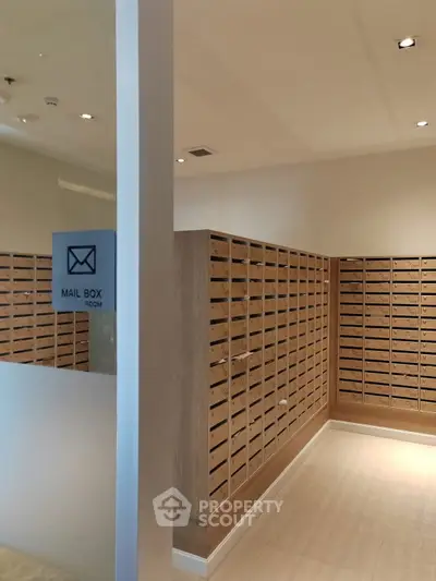 Modern mailbox room with sleek wooden mail slots and bright lighting.
