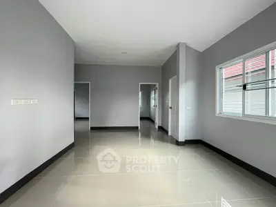 Spacious modern living room with sleek tile flooring and ample natural light.