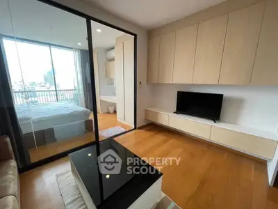 Modern living room with sleek design and city view, featuring wooden floors and built-in storage.