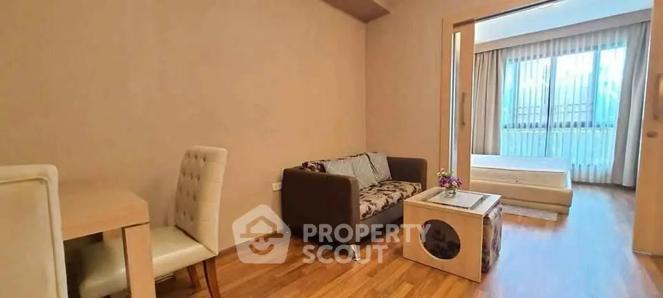 Modern open-plan living room with cozy seating and natural light in a stylish apartment.