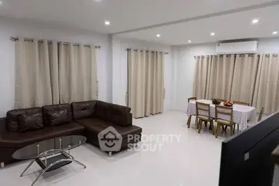 Spacious living room with modern furniture and dining area, perfect for family gatherings.