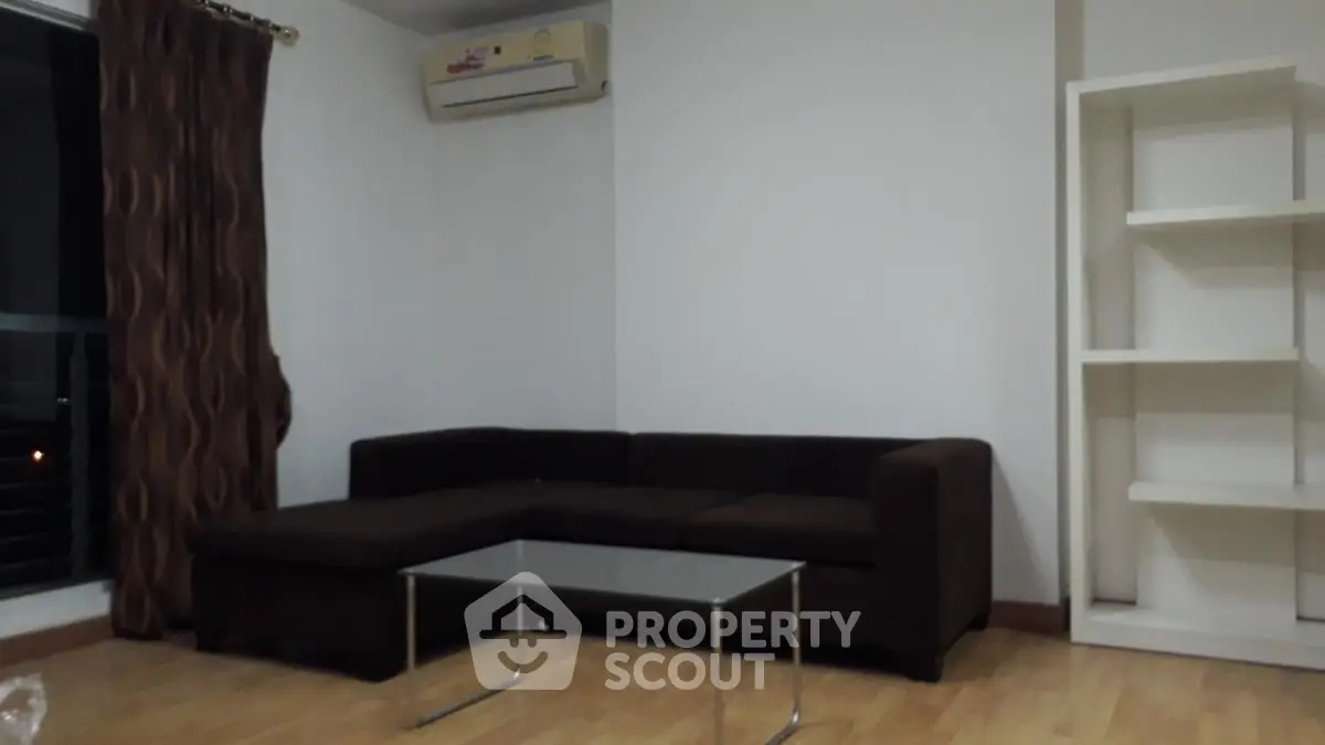 Cozy living room with dark sofa and modern glass coffee table