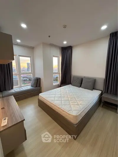 Modern bedroom with city view, featuring a cozy bed, stylish furniture, and large windows for natural light.