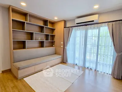 Spacious living room with built-in shelves and large window view