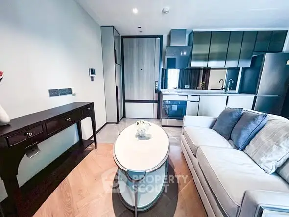Modern living room with sleek kitchen, stylish furniture, and contemporary design in a compact apartment.