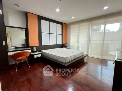 Spacious modern bedroom with hardwood floors and stylish decor