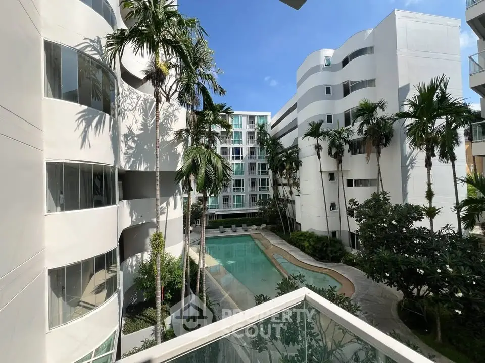 Modern apartment complex with pool and lush greenery, perfect for urban living.