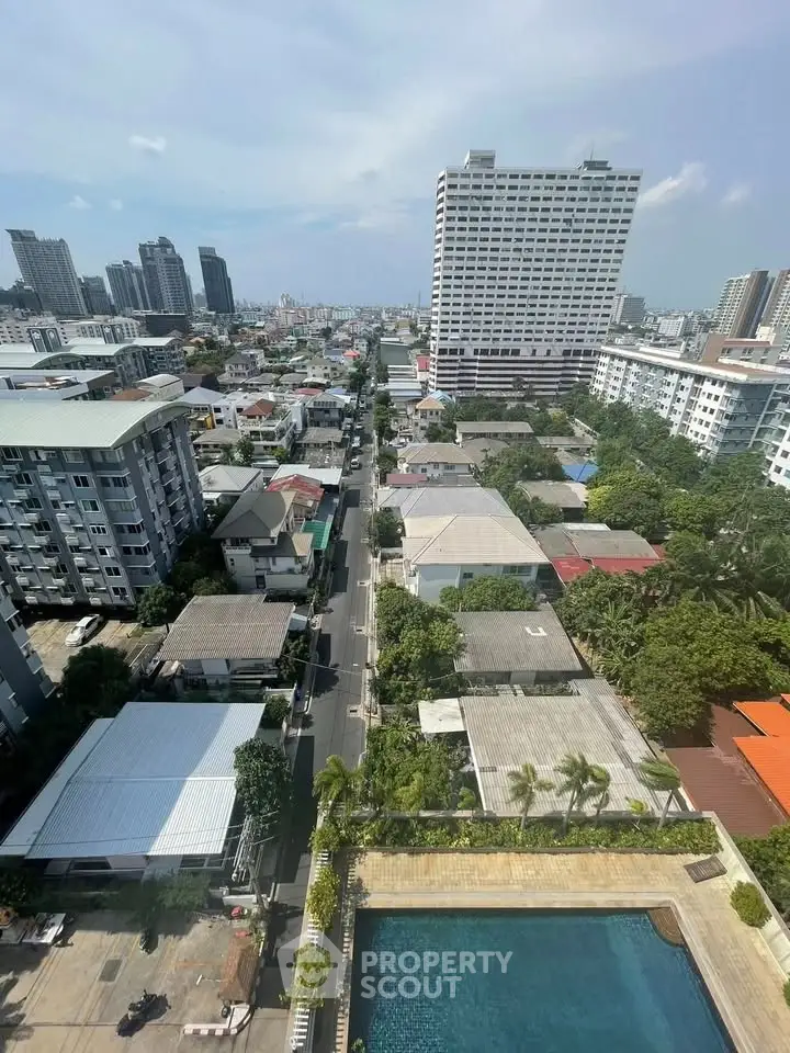 Stunning cityscape view from high-rise building with pool and lush greenery