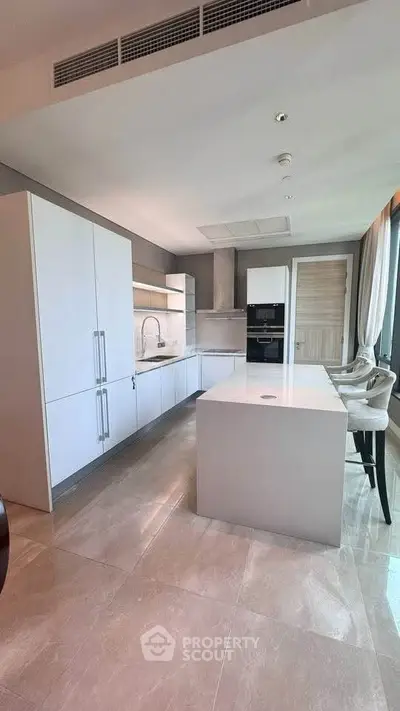 Modern kitchen with sleek white cabinetry and island in luxury apartment