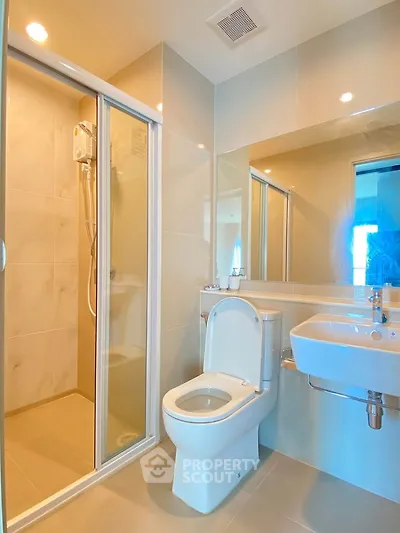 Modern bathroom with glass shower and sleek fixtures in a contemporary apartment.