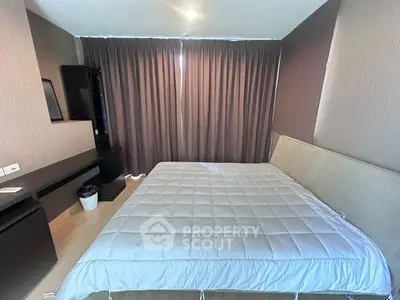 Spacious bedroom with modern decor and large window, perfect for relaxation.
