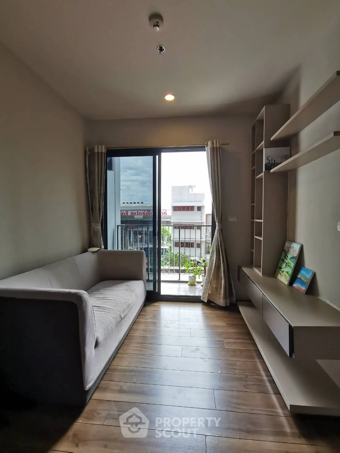 Modern living room with balcony view, featuring sleek furniture and natural light.