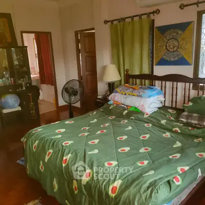 Cozy bedroom with avocado-themed bedding and wooden furniture, offering a warm and inviting atmosphere.