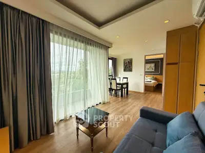 Spacious living room with large windows and modern decor in a stylish apartment.