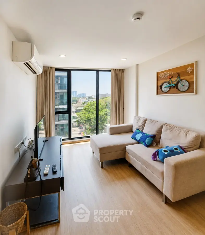 Modern living room with large window and cozy sofa in a bright apartment.