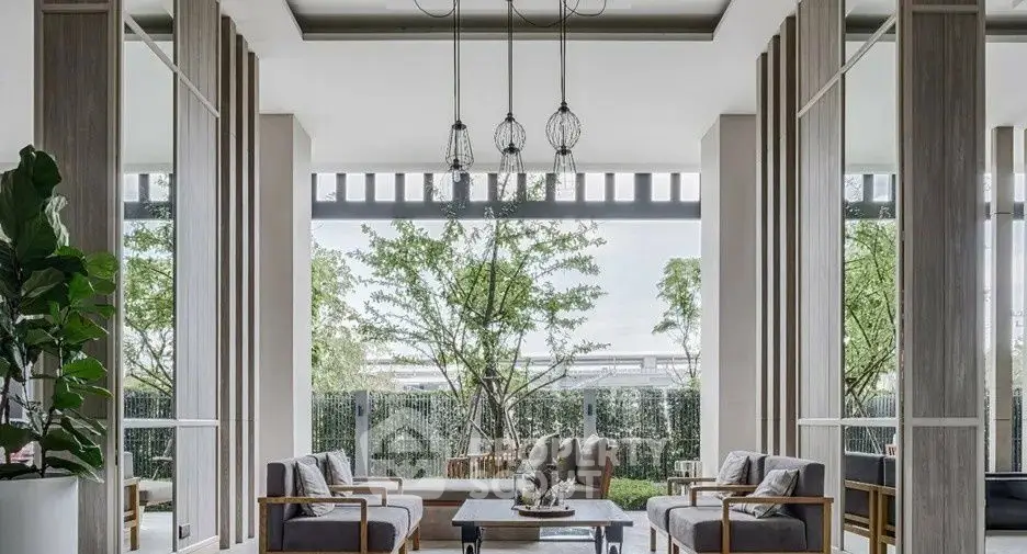 Luxurious modern living room with elegant decor and large windows overlooking greenery.