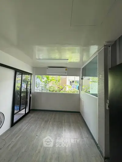 Spacious room with large windows and air conditioning, perfect for a bright and airy living space.