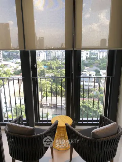 Charming balcony view with cozy seating overlooking lush greenery and cityscape.
