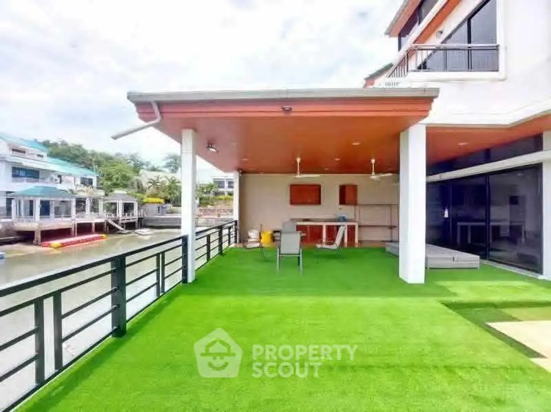 Spacious waterfront balcony with artificial grass and modern design