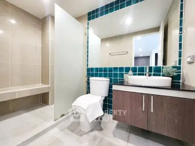 Modern bathroom with glass shower and stylish vanity in luxury apartment.