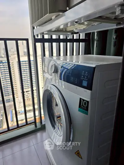 Modern washing machine on a high-rise balcony with city view, perfect for urban living convenience.