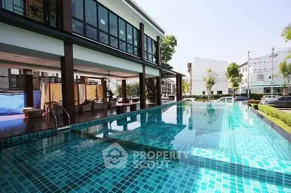 Luxurious modern building with a stunning outdoor pool and lush surroundings, perfect for relaxation and leisure.