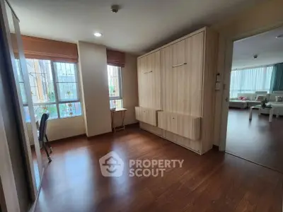 Spacious bedroom with wooden flooring and ample natural light