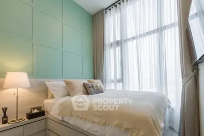 Modern bedroom with large windows and stylish decor in a high-rise apartment.