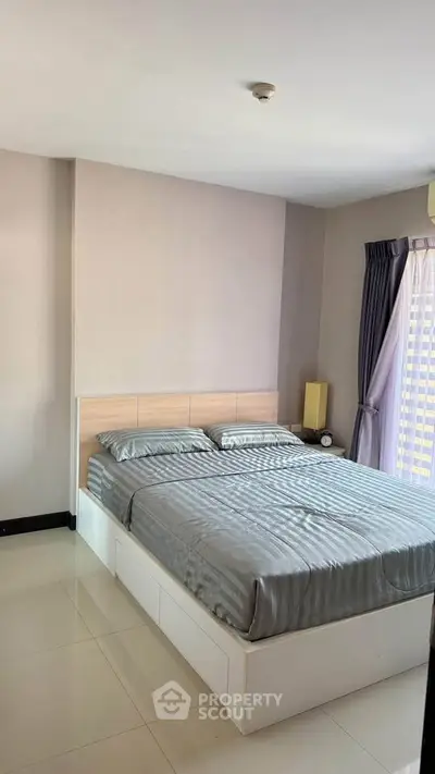 Modern bedroom with sleek design and natural light, featuring a comfortable bed and stylish decor.