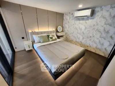 Modern bedroom with stylish decor and ambient lighting, featuring a comfortable bed and elegant wall design.