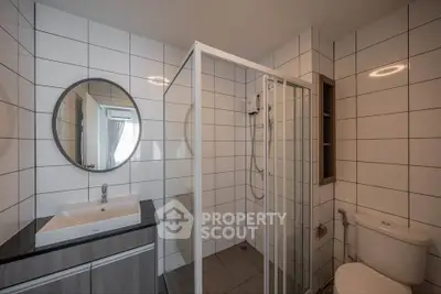 Modern bathroom with sleek shower and stylish vanity in contemporary apartment.