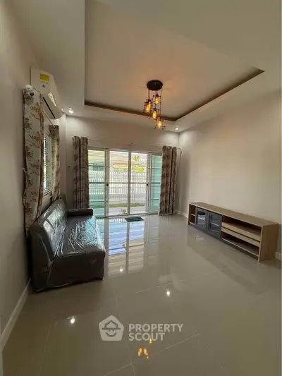 Spacious living room with modern lighting and large windows for natural light.