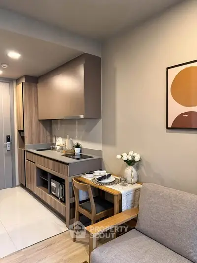 Modern kitchen with sleek cabinetry and cozy dining area in stylish apartment.