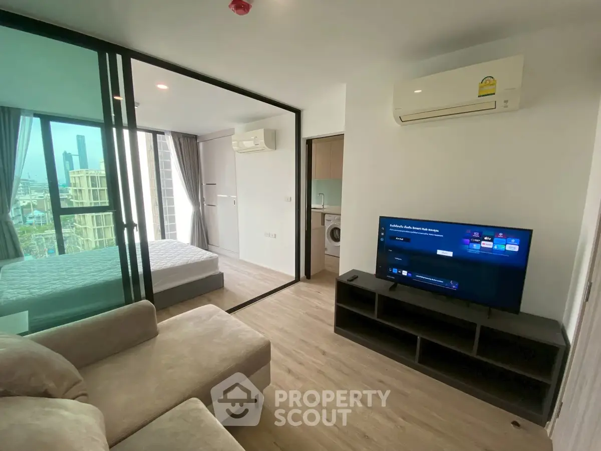 Modern apartment interior with living room and bedroom view, featuring sleek design and natural light.