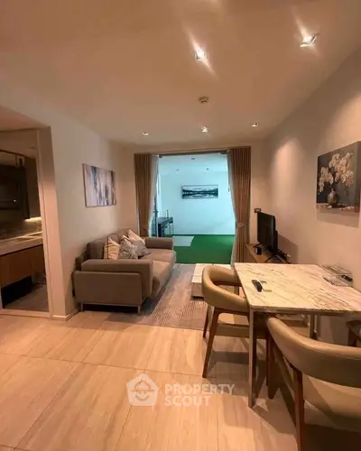 Modern living room with elegant decor and open layout leading to a bright extension area.