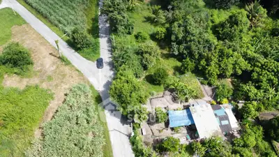 Aerial view of rural property with lush greenery and a small house, ideal for nature lovers seeking tranquility.