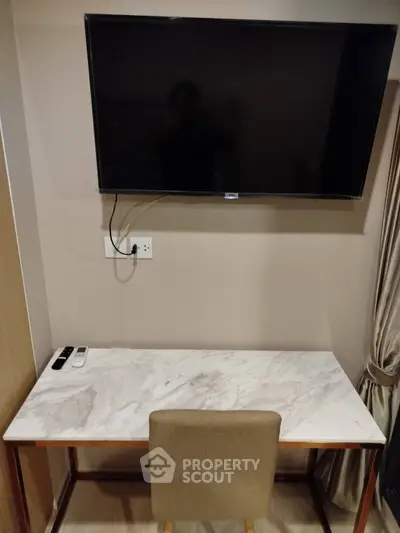 Modern study area with marble desk and wall-mounted TV in elegant interior design.