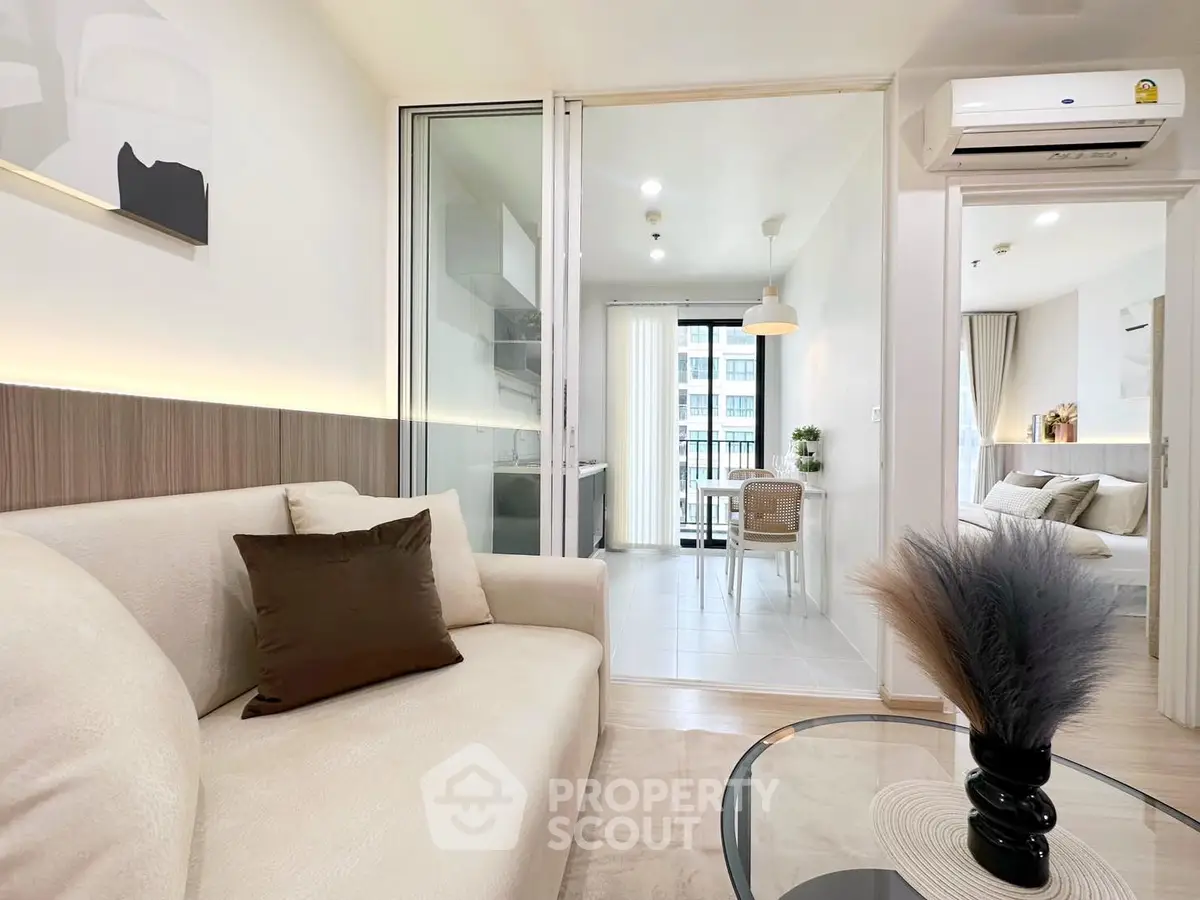 Modern living room with elegant decor and open view to dining area and balcony.