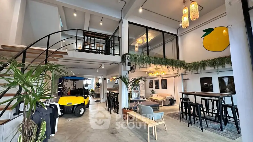 Stylish open-concept living space with mezzanine, modern decor, and unique golf cart feature.